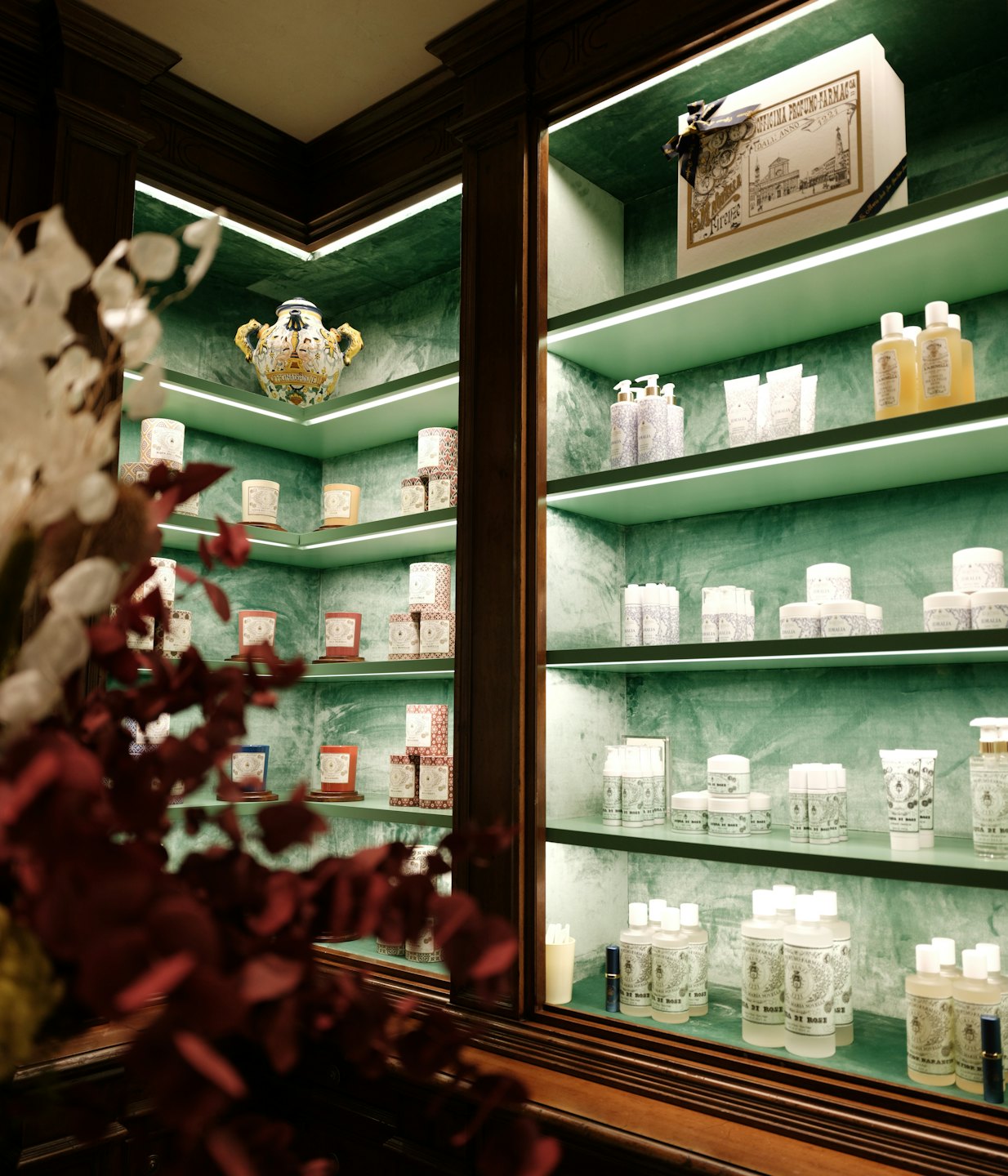 Luxury beauty products displayed on mint green shelves.